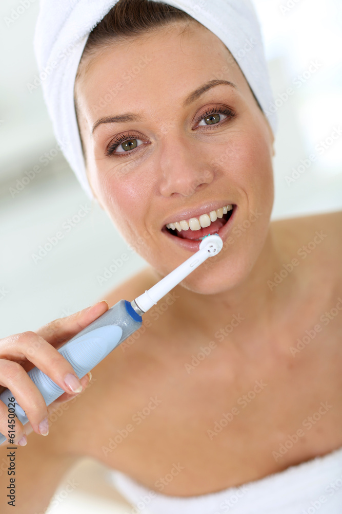 Woman brushing her teeth with electrical toothbrush Woman brushing her teeth with electrical toothbrush