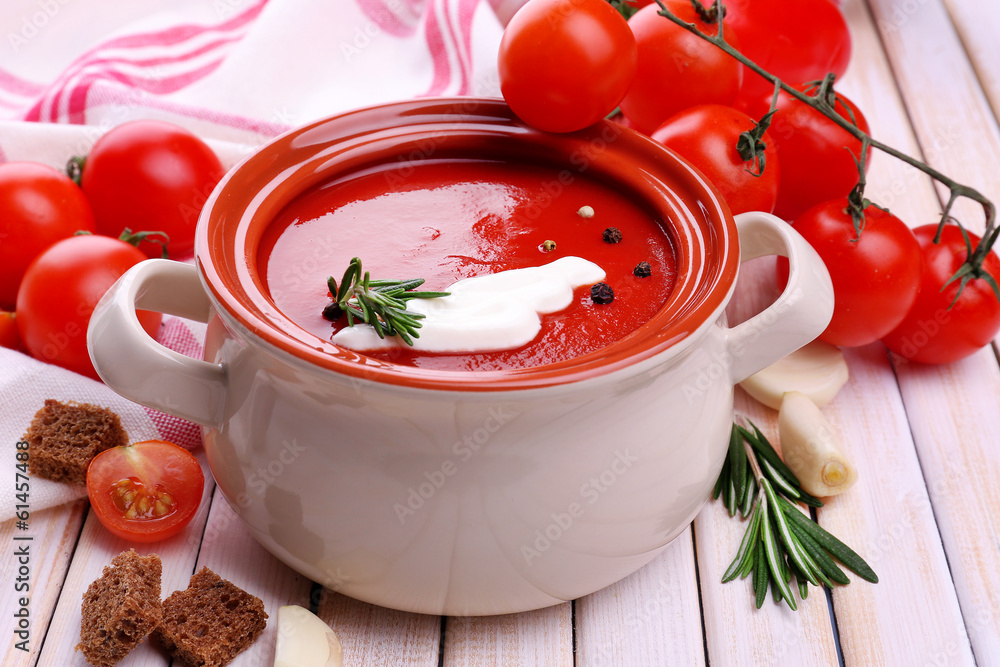 Tasty tomato soup and vegetables on wooden table Tasty tomato soup and vegetables on wooden table