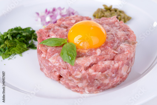Delicious steak tartare with yolk on plate close-up