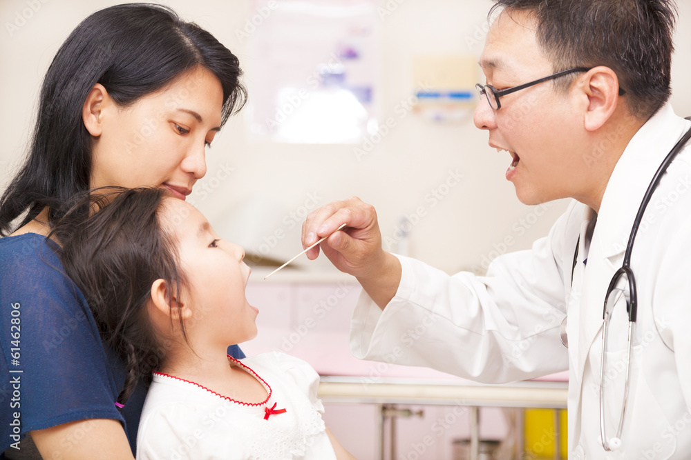 Obraz premium Pediatrician checking little girl throat