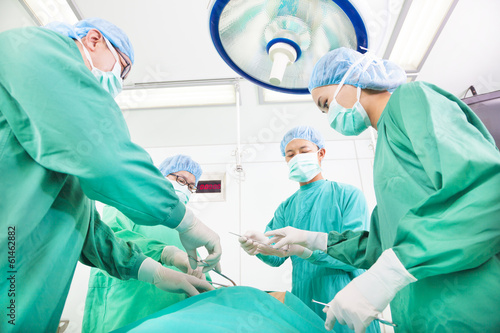 Team surgeon working in operating room.
