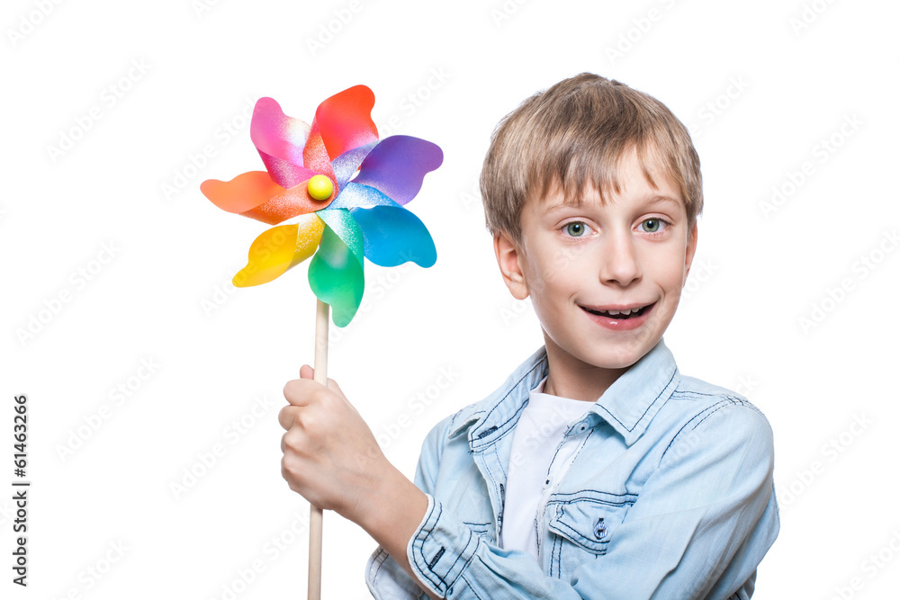 Beautiful cheerful blond boy holds a multicolored pinwheel Beautiful cheerful blond boy holds a multicolored pinwheel
