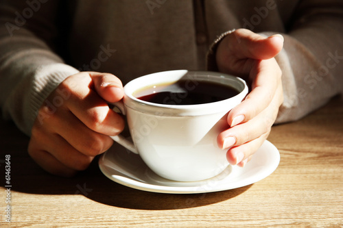 Hands holding mug of hot drink, close-up