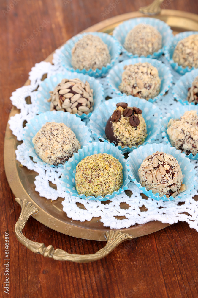 Set of chocolate candies, on tray, on wooden background Set of chocolate candies, on tray, on wooden background