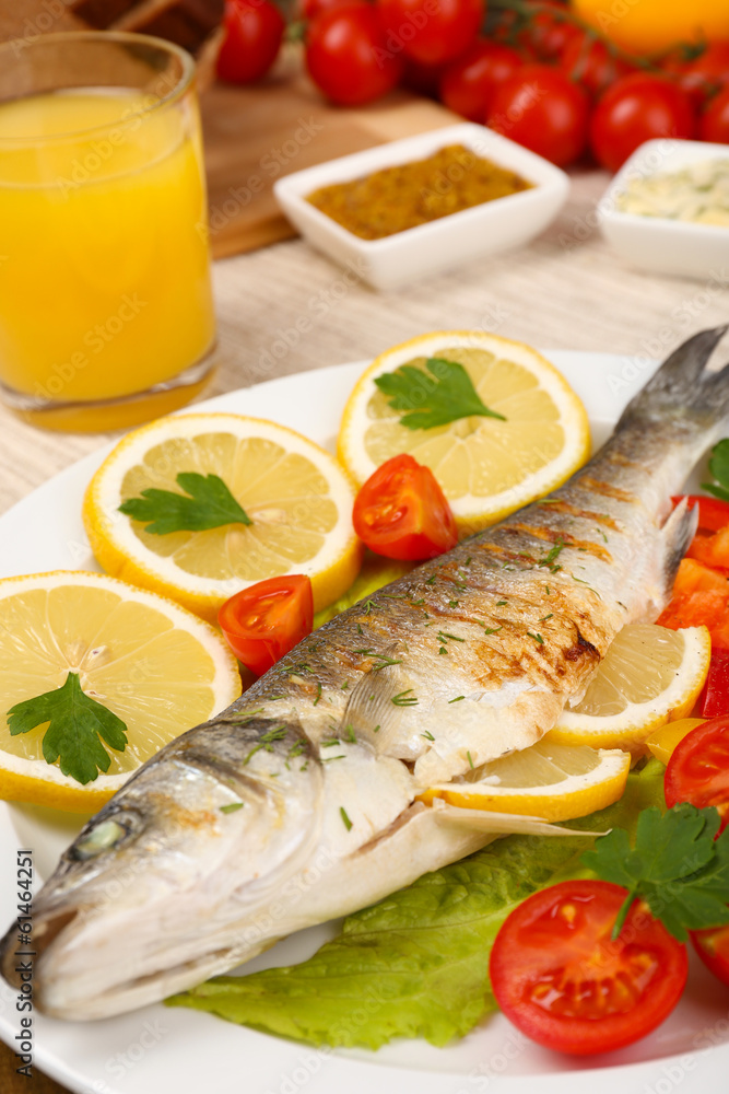 Delicious grilled fish on plate on table close-up