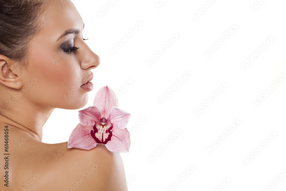 Side view of a girl posing with orchid on white background