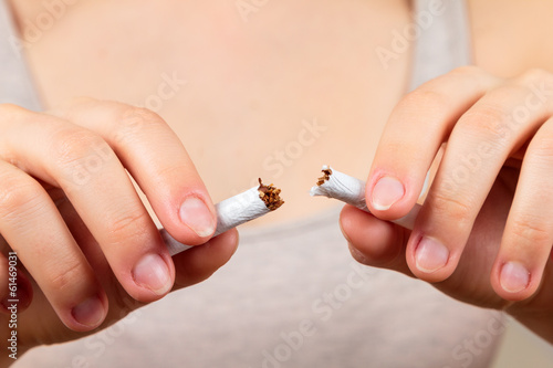 woman breaking a cigarette  quit smoking concept 