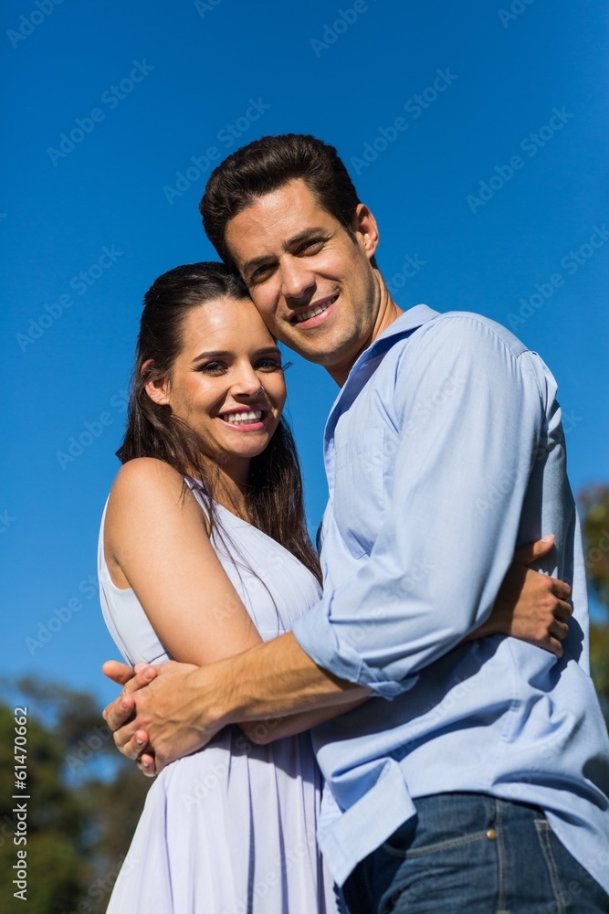 Loving couple embracing each other against clear blue sky Loving couple embracing each other against clear blue sky