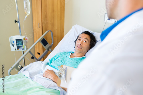 Patient Looking At Doctor While Lying On Bed In Hospital
