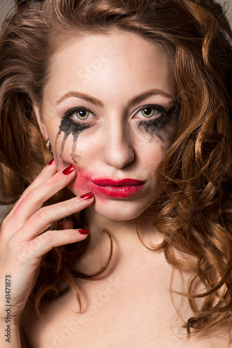 Attractive girl with smeared make-up and polished nails