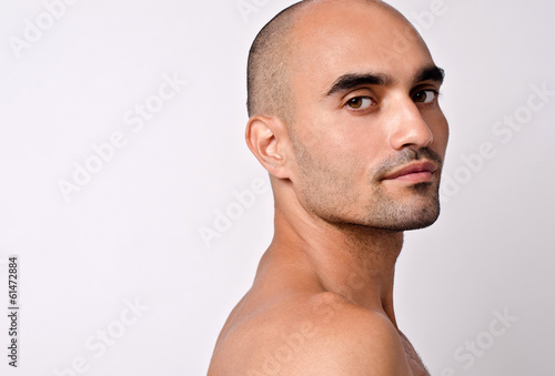  Portrait of a beautiful bald man looking over his shoulder. 