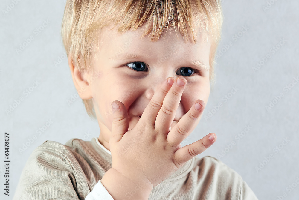 shy blond boy hide his nose and mouth with hid hand shy blond boy hide his nose and mouth with hid hand