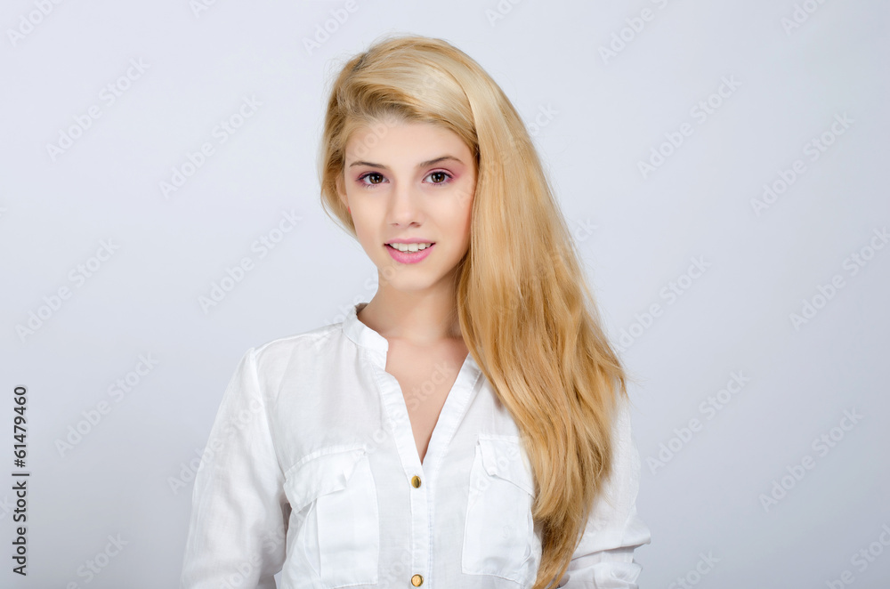 Portrait of a beautiful young blonde girl in white shirt smiling Portrait of a beautiful young blonde girl in white shirt smiling