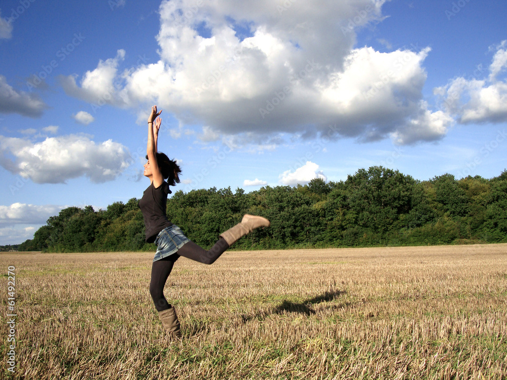 junge Frau springt in einem Feld junge Frau springt in einem Feld
