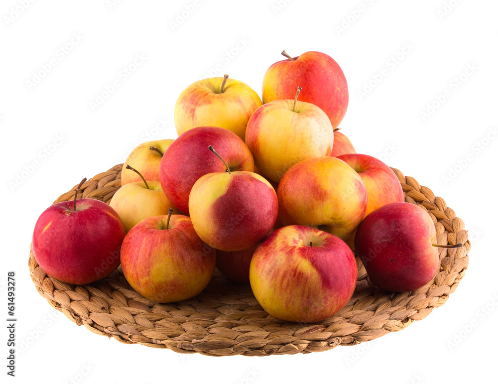 Red and yellow apples on a straw mat, isolated Red and yellow apples on a straw mat, isolated