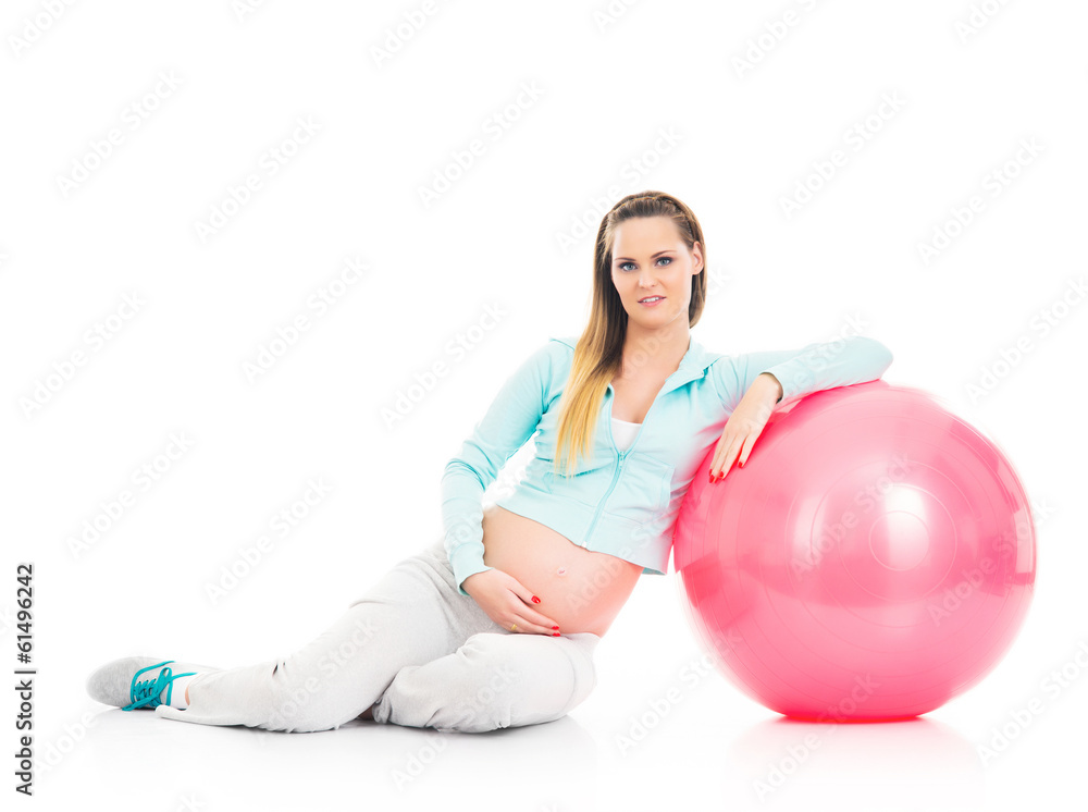 A young pregnant woman working out with a fitness ball A young pregnant woman working out with a fitness ball