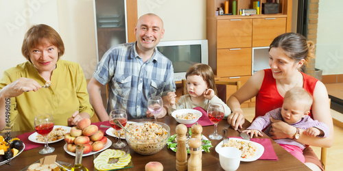 happy three generations family posing  over celebratory table