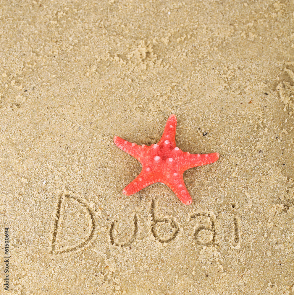 Inscription Dubai in wet sand close-up background Inscription Dubai in wet sand close-up background