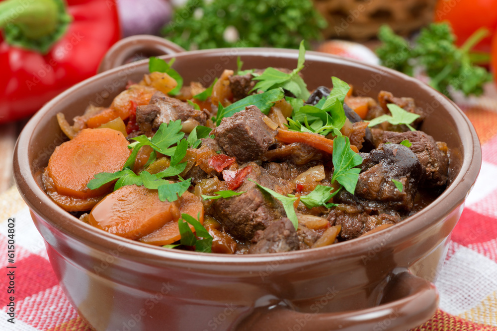 Stew with beef, vegetables and prunes in a saucepan, close-up Stew with beef, vegetables and prunes in a saucepan, close-up