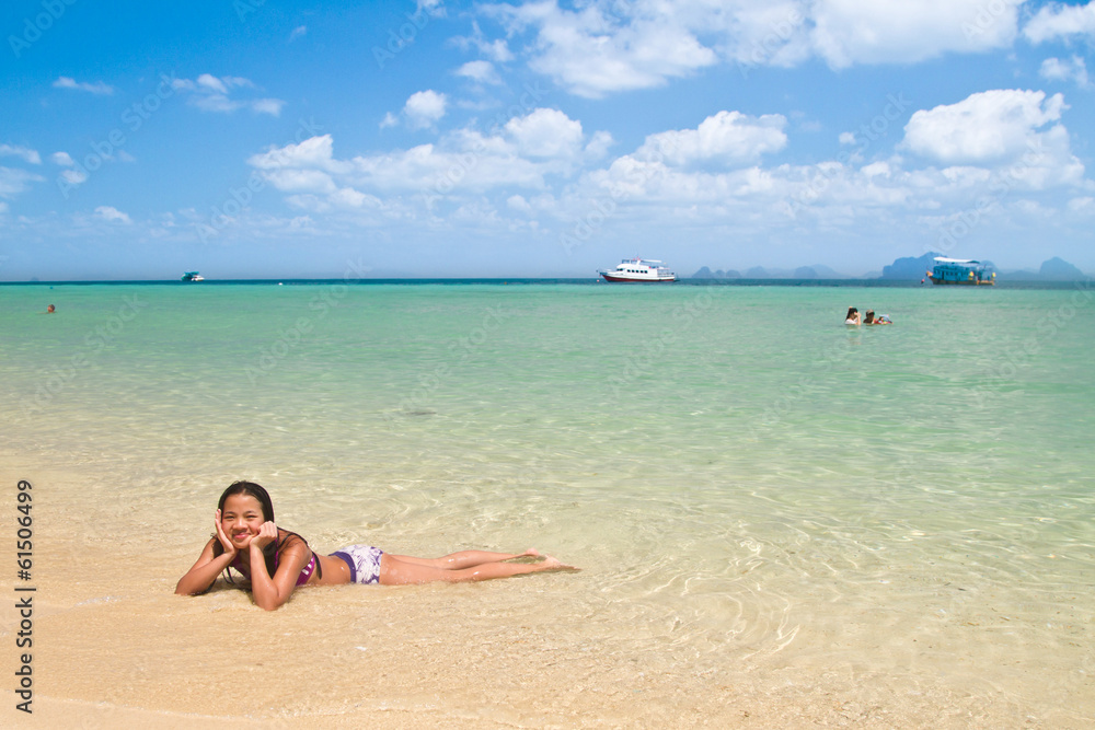 Girl lying in the water at the beach of the Koh Ngai island Thai Girl lying in the water at the beach of the Koh Ngai island Thai