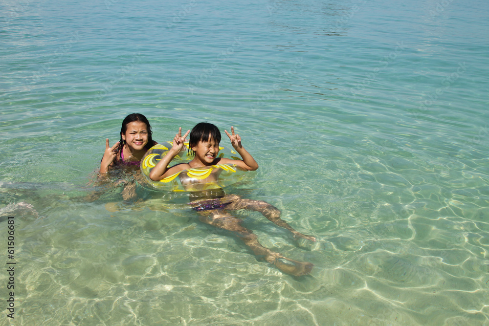 Two girls swimming in the water at the beach of the Koh Ngai isl