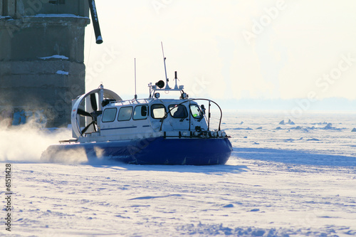 Foto Hovercraft crossing frozen river in the sunny day