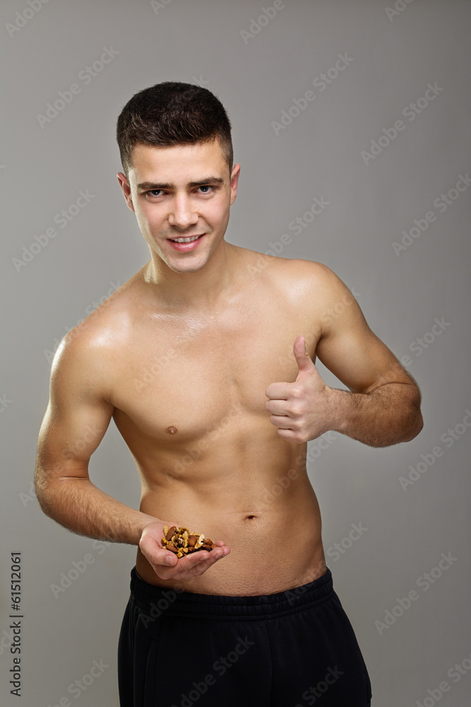 Positive fit man holding various healthy nuts Positive fit man holding various healthy nuts
