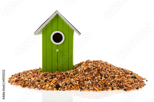 Green and red bird houses with seed