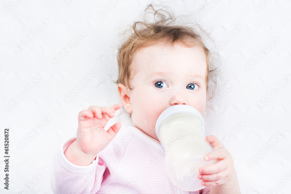 Little baby girl drinking milk out of a bottle Little baby girl drinking milk out of a bottle
