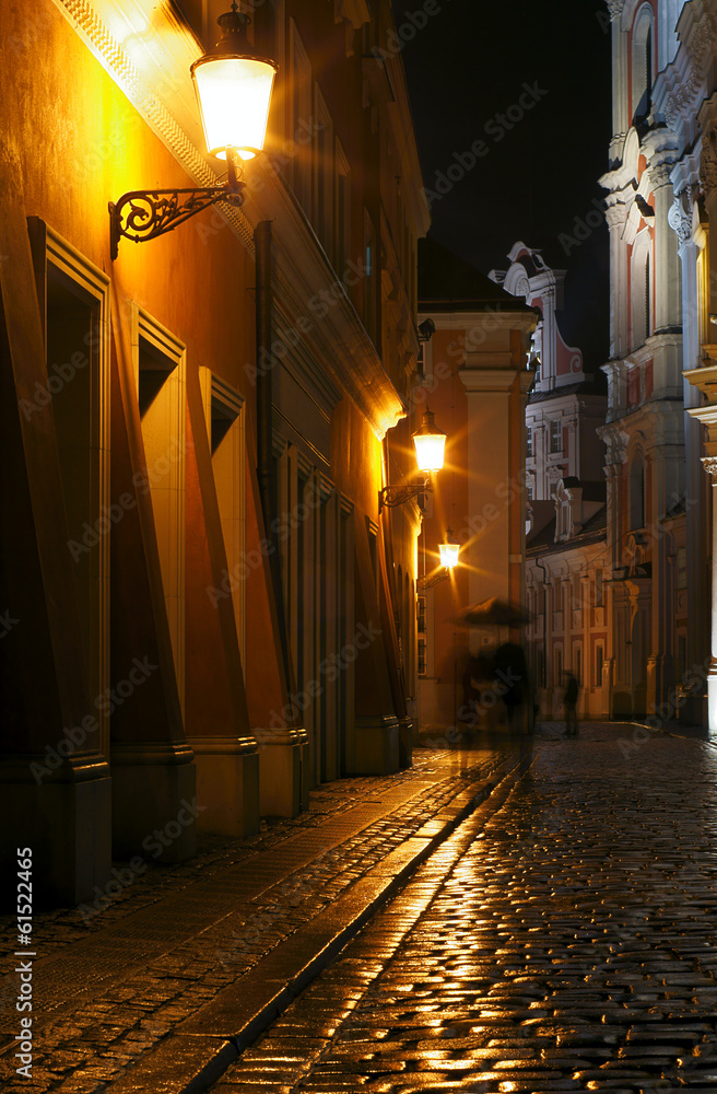 Rainy walk the cobbled street at night in Poznan .