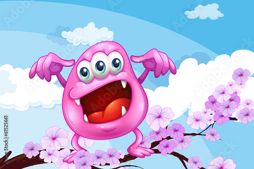 A pink beanie monster above the branch of a tree