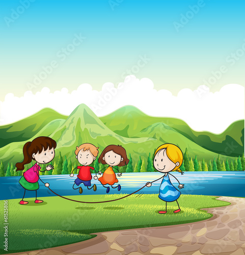 Four kids playing with a rope near the river