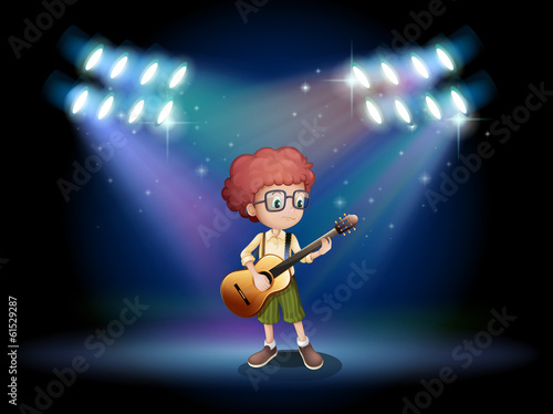 A talented teenager in the middle of the stage with a guitar