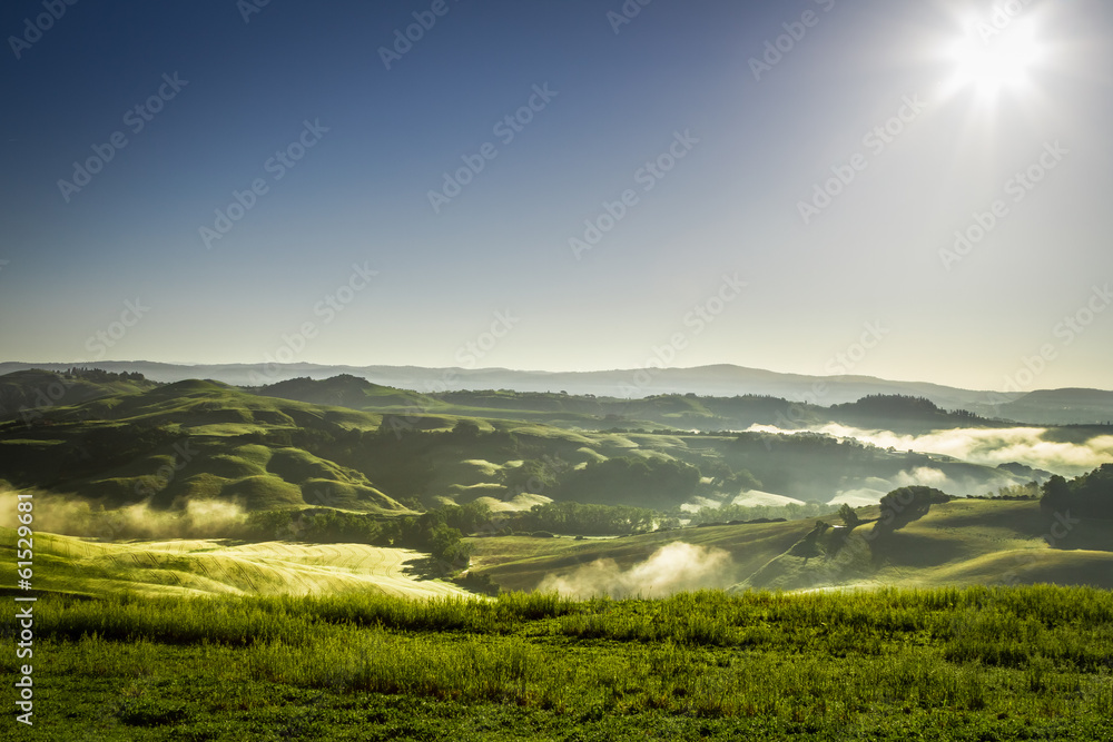 Misty hills in Tuscany at sunrise