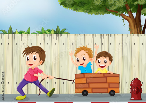 Three boys playing near the wooden wall
