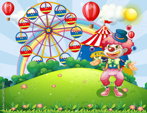 A clown juggling at the hilltop across the carnival