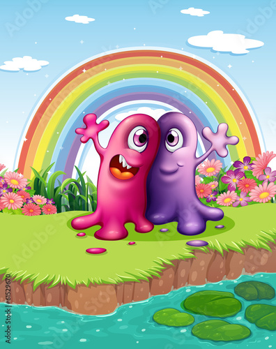 Two monsters at the riverbank with a rainbow in the sky