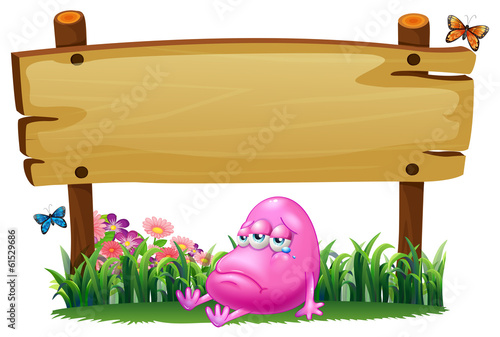 A sad pink monster under the empty signboard