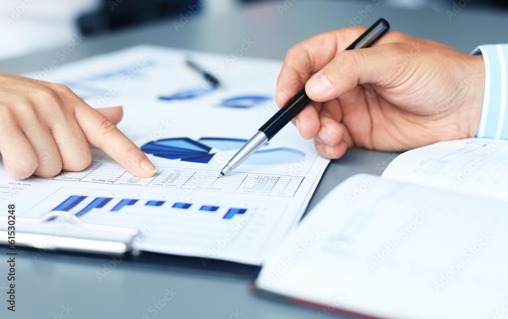 Unrecognizable business person analyzing graphs Unrecognizable business person analyzing graphs