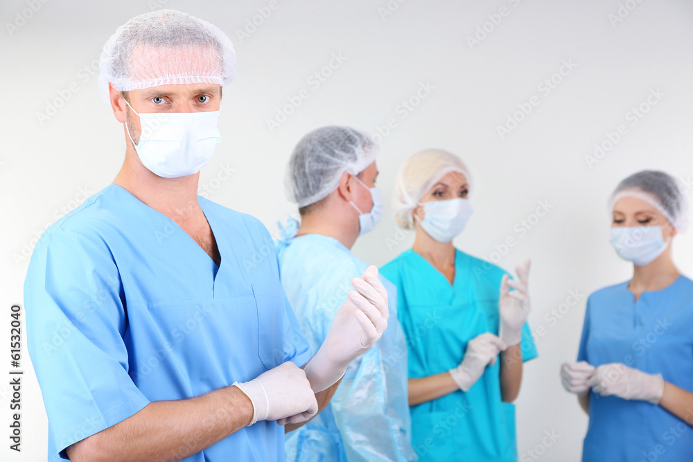 Surgeons standing on grey background Surgeons standing on grey background