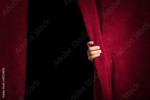Hand appearing beneath the curtain. photo
