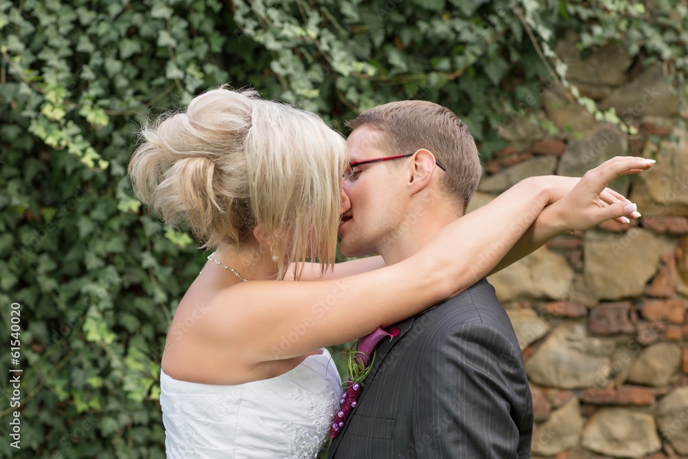 Naklejka premium Groom kissing bride on their wedding day.