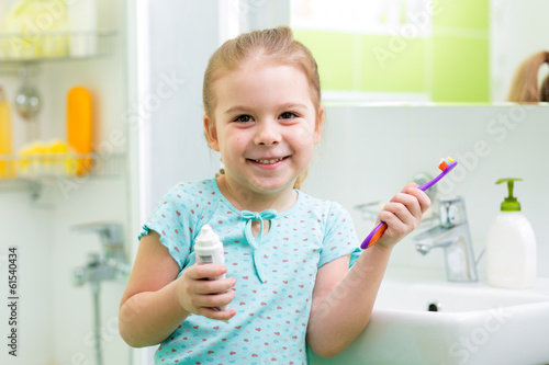 Child girl brushing teeth i...