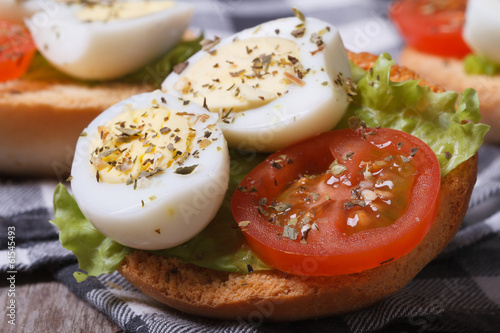 Small sandwich with quail eggs, tomato and lettuce