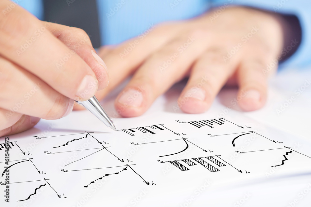 Businessman drawing bar chart and other infographics in note pad Businessman drawing bar chart and other infographics in note pad