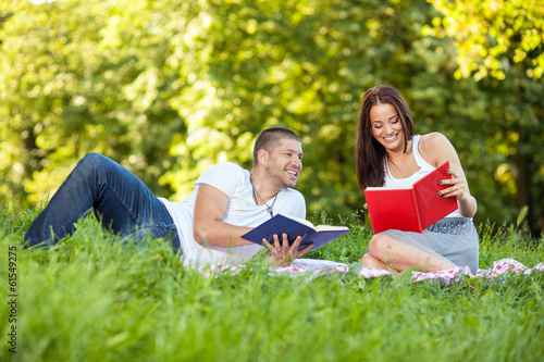 Young couple reading book in park