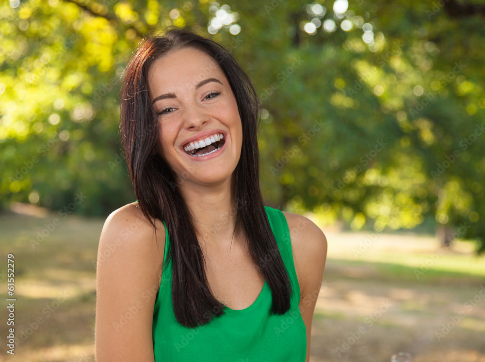 Friendly young woman with toothy smile outdoors portrait Friendly young woman with toothy smile outdoors portrait