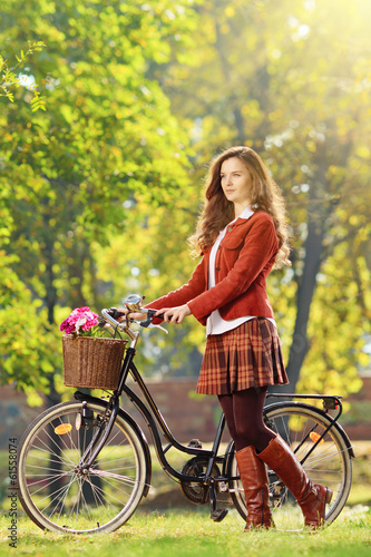 Young female with bicycle relaxing in a park