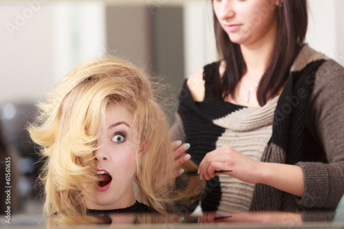 Surprised shocked female client blond girl in hairdressing salon