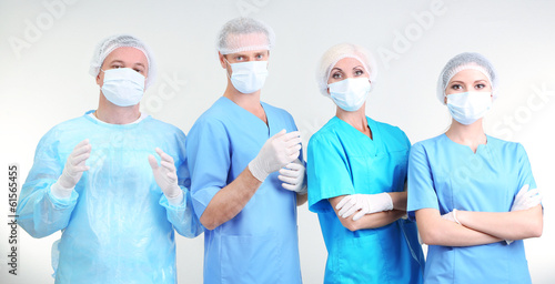 Surgeons standing on grey b...